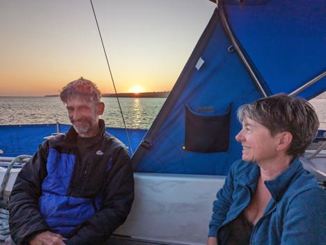 Smiling couple in cockpit at sunset